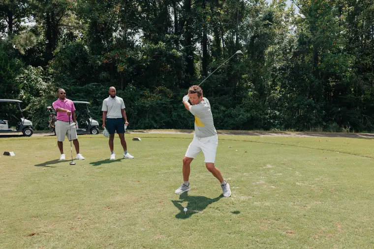 A group of four golfers walking a fairway